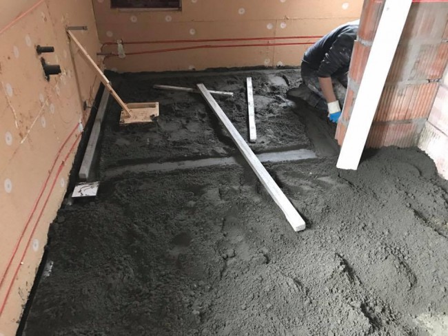 Met zandcement wordt de badkamer vloer op hoogte gebracht
