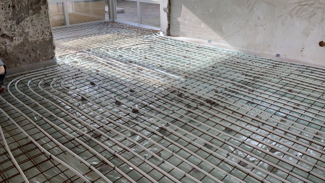 De vloerverwarming ligt klaar om in de betonvloer gegoten te worden